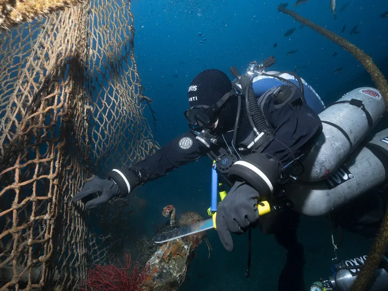 Working a section of net free of the wreck.