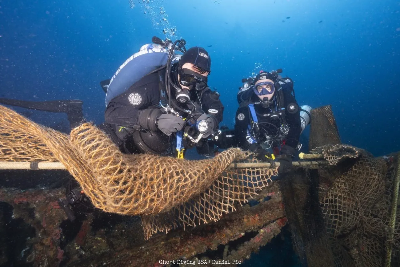 Divers removing and documenting net on the wreck